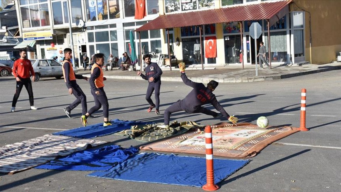 Sahası olmayan futbolcular, asfalta kilim serip antrenman yapıyor