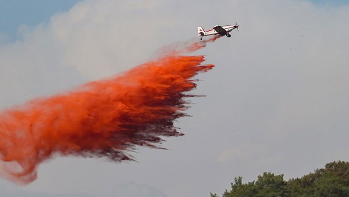 Marmaris'te uçaklardan atılan suya rengini veren kırmızı ürün, toprağın beslenmesini sağlıyor